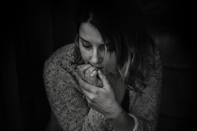 photo of a woman biting her fingernails who is anxious