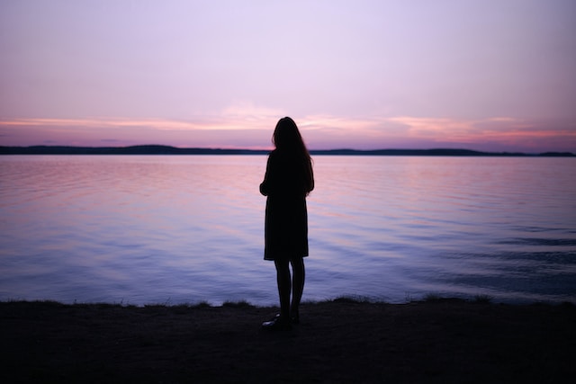 silhouette of a woman who is looking out at the water