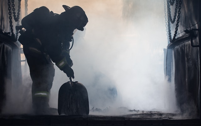 photo of a firefighter leaning down to pick up his equipment