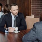 photo of two men in business suits talking at a table