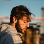 photo of a man sitting on a bench near a city park