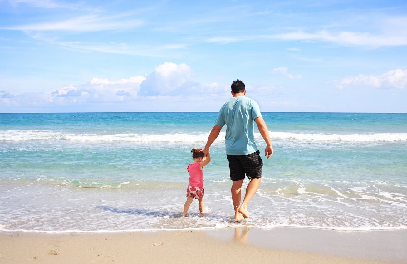 dad with kid walking by the shore